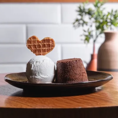 Petit gateau ao lado de uma bola de gelato com waffle em formato de coração